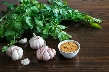 Image showing Parsley leaves and garlic on the surface of the table.