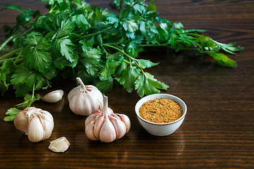 Image showing Parsley leaves and garlic on the surface of the table.