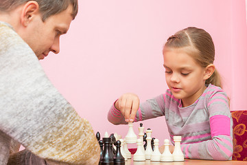 Image showing Girl makes the next move while playing chess with the coach