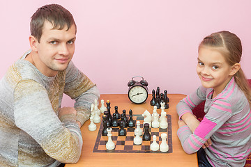 Image showing Dad and daughter playing chess with a smile and looked into the frame