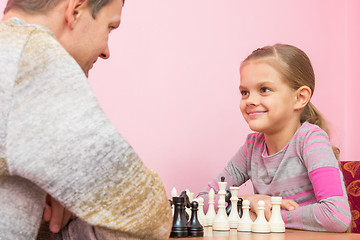 Image showing Dad and daughter happily look at each other, playing chess