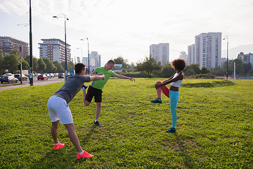 Image showing multiethnic group of people stretching in city park