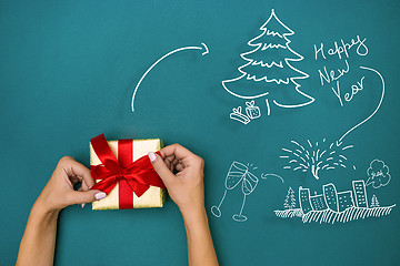 Image showing Female hands holding gift on blue background