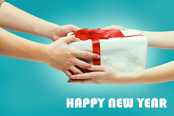 Image showing Female and male hands holding gift on blue background