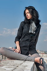 Image showing Young cool woman relaxes on roof