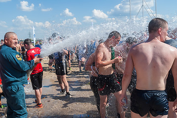 Image showing Firefighter pours water athletes after finishing