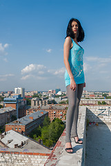 Image showing Attractive serious woman stands on building roofroof