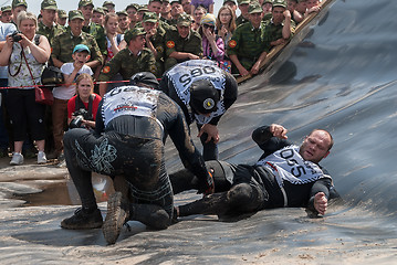 Image showing Men give first aid to companion on race. Tyumen