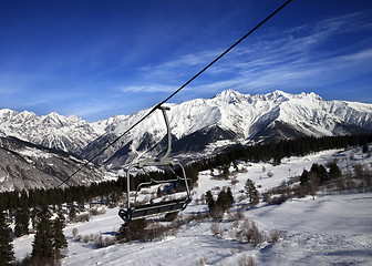 Image showing Chair-lift at ski resort and snow winter mountains at nice sun d