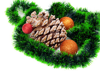 Image showing Big pine cone, green Christmas tinsel and Christmas-tree balls