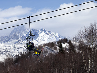 Image showing Father and daughter on ski-lift at winter sun day