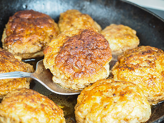 Image showing Frying homemade meatballs in black iron pan, in fine broth