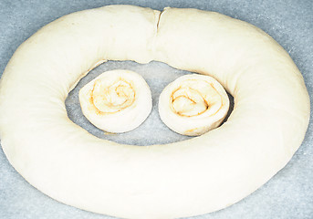 Image showing Closeup of raw cinnamon roll and cinnamon buns on baking paper