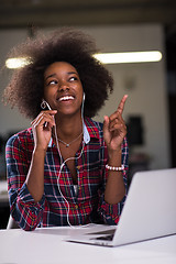 Image showing black woman in modern office at her workplace speeking on phone 