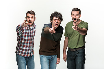 Image showing The three men are smiling, looking and pointing at camera