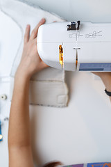 Image showing Girl tailoring fabric on sewing-machine