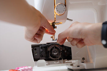 Image showing Woman prepares sewing-machine to work