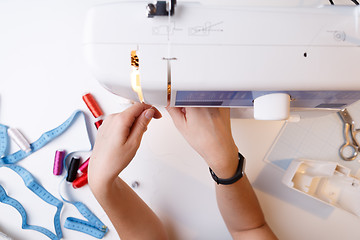 Image showing Woman sets up sewing machine