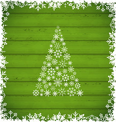 Image showing  Christmas pine and border made of snowflakes on green wooden ba