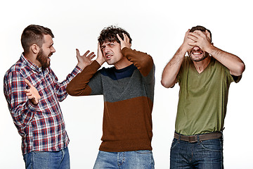 Image showing The three men looking with different emotions