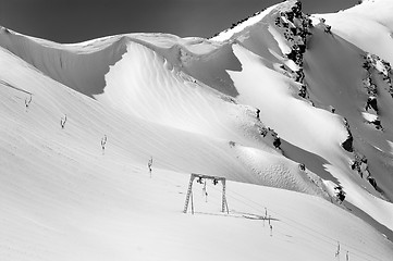 Image showing Black and white view on old surface lift and mountains with snow