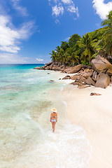 Image showing Woman enjoying Anse Patates picture perfect beach on La Digue Island, Seychelles.