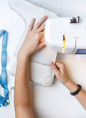 Image showing Girl tailoring boot on sewing-machine