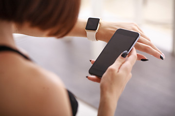 Image showing using her smartwatch and phone at home in the living room