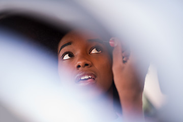 Image showing a young African-American woman makeup in the car