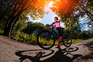 Image showing Young woman having fun riding a bicycle in the park.