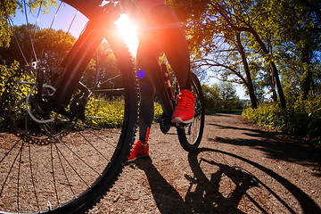 Image showing Young woman having fun riding a bicycle in the park.