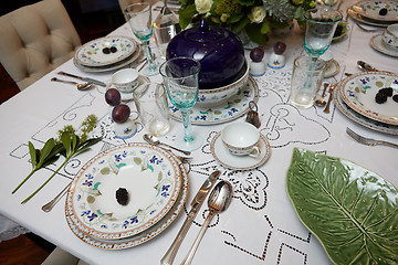 Image showing Beautifully decorated table set with flowers, candles, plates and serviettes for wedding or another event in the restaurant.