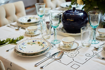 Image showing Beautifully decorated table set with flowers, candles, plates and serviettes for wedding or another event in the restaurant.