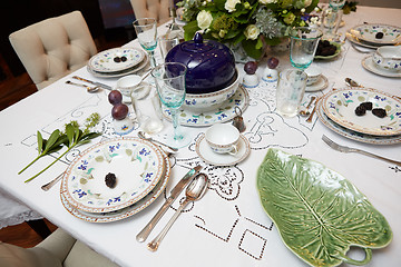 Image showing Beautifully decorated table set with flowers, candles, plates and serviettes for wedding or another event in the restaurant.