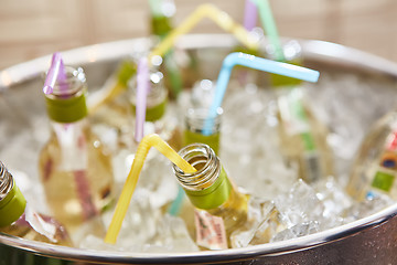 Image showing bottles with tasty drink in ice. Shallow dof