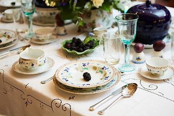 Image showing Beautifully decorated table set with flowers, candles, plates and serviettes for wedding or another event in the restaurant.