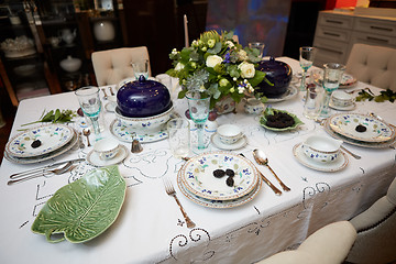 Image showing Beautifully decorated table set with flowers, candles, plates and serviettes for wedding or another event in the restaurant.