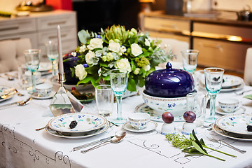 Image showing Beautifully decorated table set with flowers, candles, plates and serviettes for wedding or another event in the restaurant.