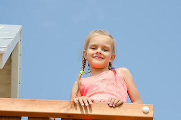 Image showing Happy girl climbed on the playground and looked down smiling