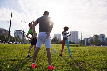 Image showing multiethnic group of people stretching in city park