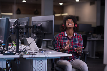 Image showing woman at her workplace in startup business office listening musi