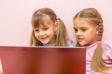 Image showing Two girls looking at laptop and smiling