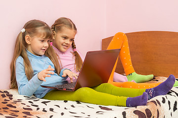 Image showing Two girls sitting on the bed with laptop