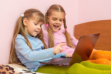 Image showing Two girls include laptop at work, sitting on the bed