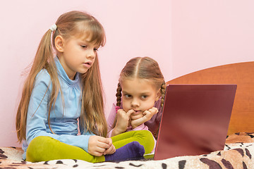 Image showing The sisters are interested in watching a laptop screen