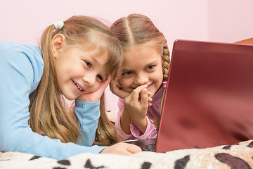 Image showing Sisters watching a cartoon on a laptop and laughing at a funny moment