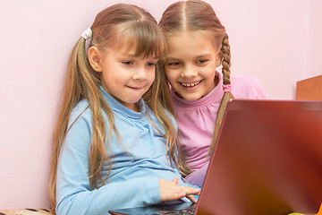 Image showing Two girls playing in a notebook fun laughing