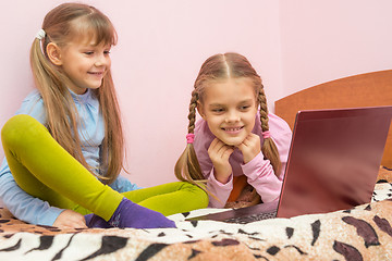 Image showing Two girls looking at a laptop and laughing together having fun