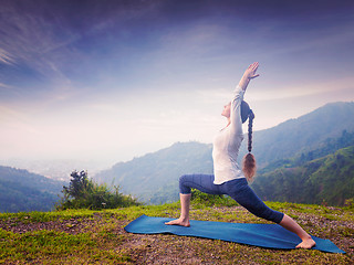 Image showing Woman doing yoga asana Virabhadrasana 1 - Warrior pose outdoors