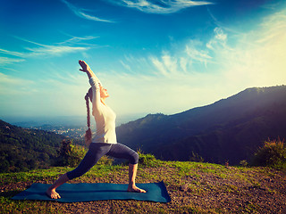 Image showing Woman doing yoga asana Virabhadrasana 1 - Warrior pose outdoors